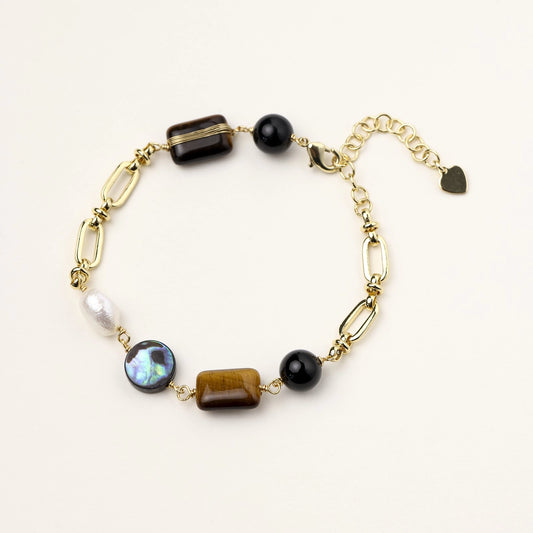 Gold paperclip chain bracelet featuring caramel tiger's eye, glossy black obsidian, iridescent pearl, and a heart charm.