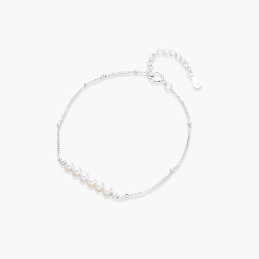 Delicate bracelet featuring six baroque pearls centred on a refined silver chain, showcasing minimalist elegance.