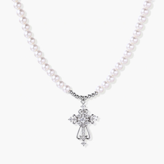Elegant white pearl necklace featuring a scrolled silver cross pendant adorned with sparkling zirconia stones.
