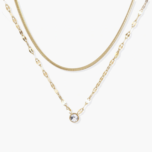 Dual-chain necklace featuring a sleek snake chain and delicate flat-link chain, adorned with a radiant clear crystal pendant.