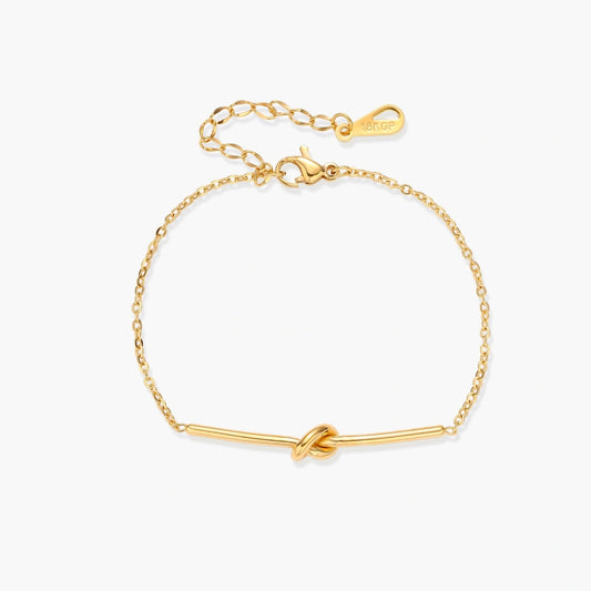 Delicate gold chain bracelet featuring a minimalist bar and a central knot detail, exuding elegance and sophistication.
