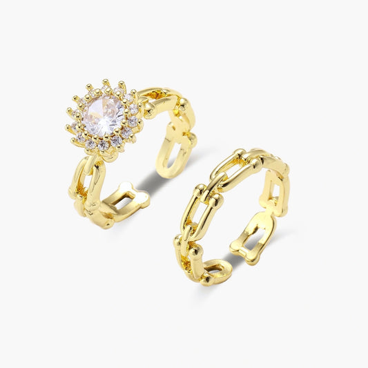 Two elegant gold rings featuring a halo cubic zirconia design and a chunky chain link band.