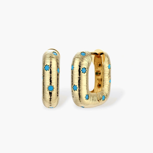 Gold-plated huggie hoop earrings with blue star inlays and textured surface, shown against white background.