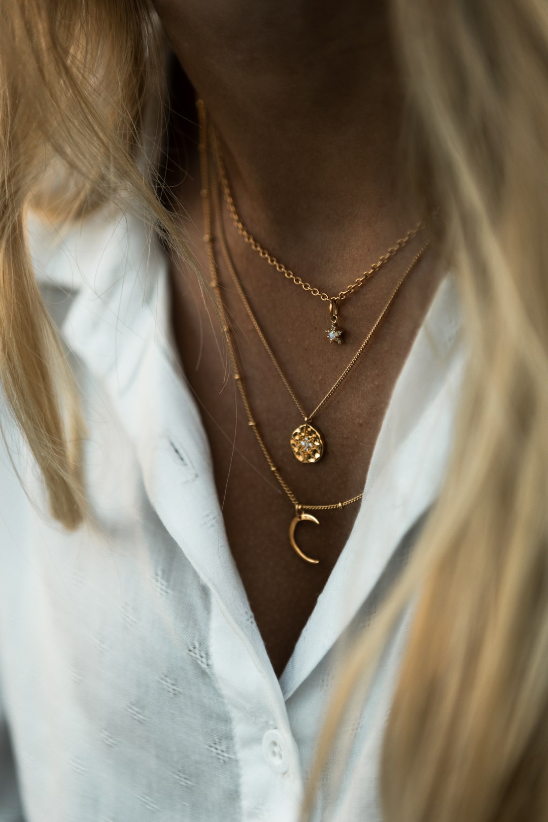 woman wearing gold necklace and white shirt - Photo by Max Ducourneau on Unsplash