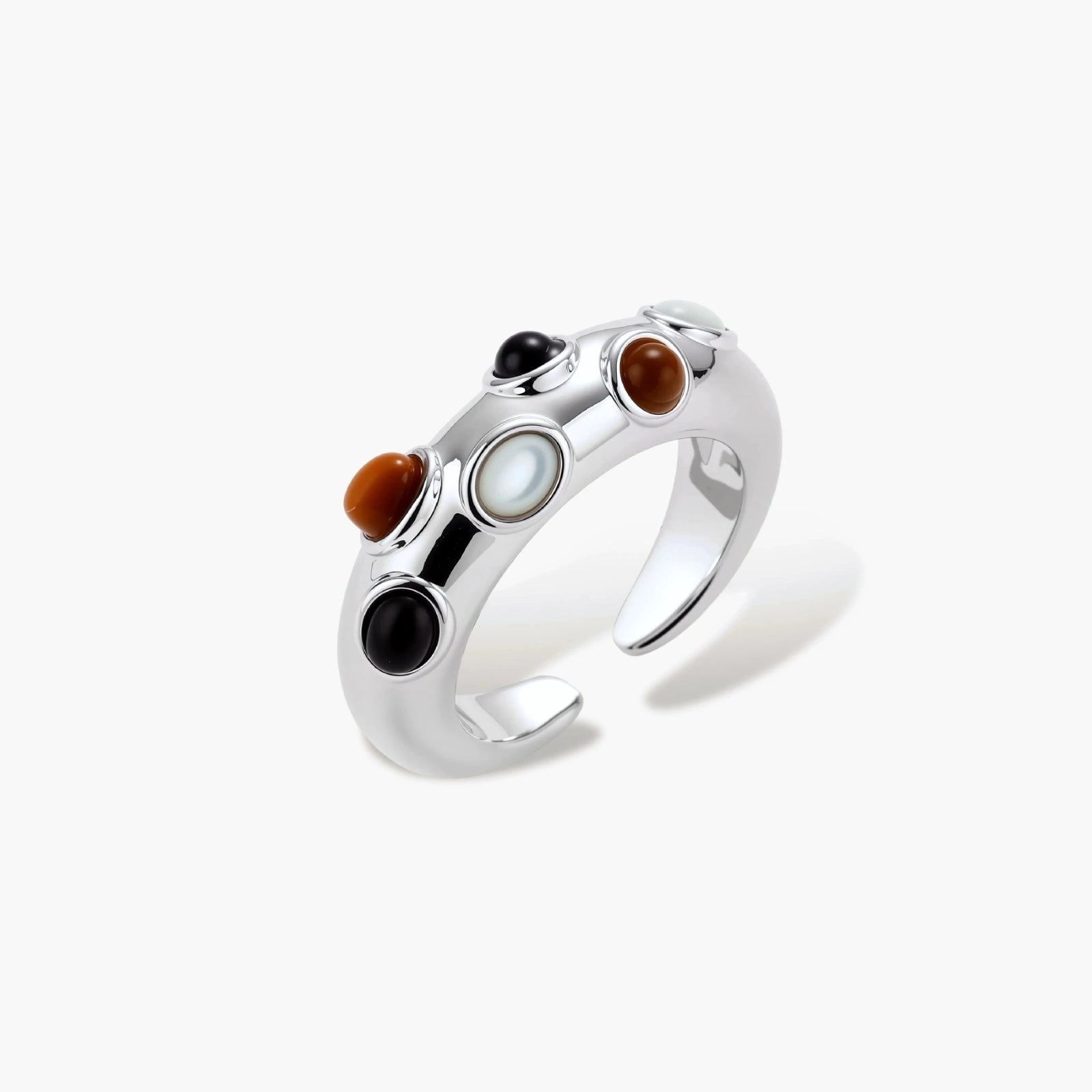 Domed adjustable ring featuring black, caramel, and white cabochons on a polished finish. Ideal for elegant styling.