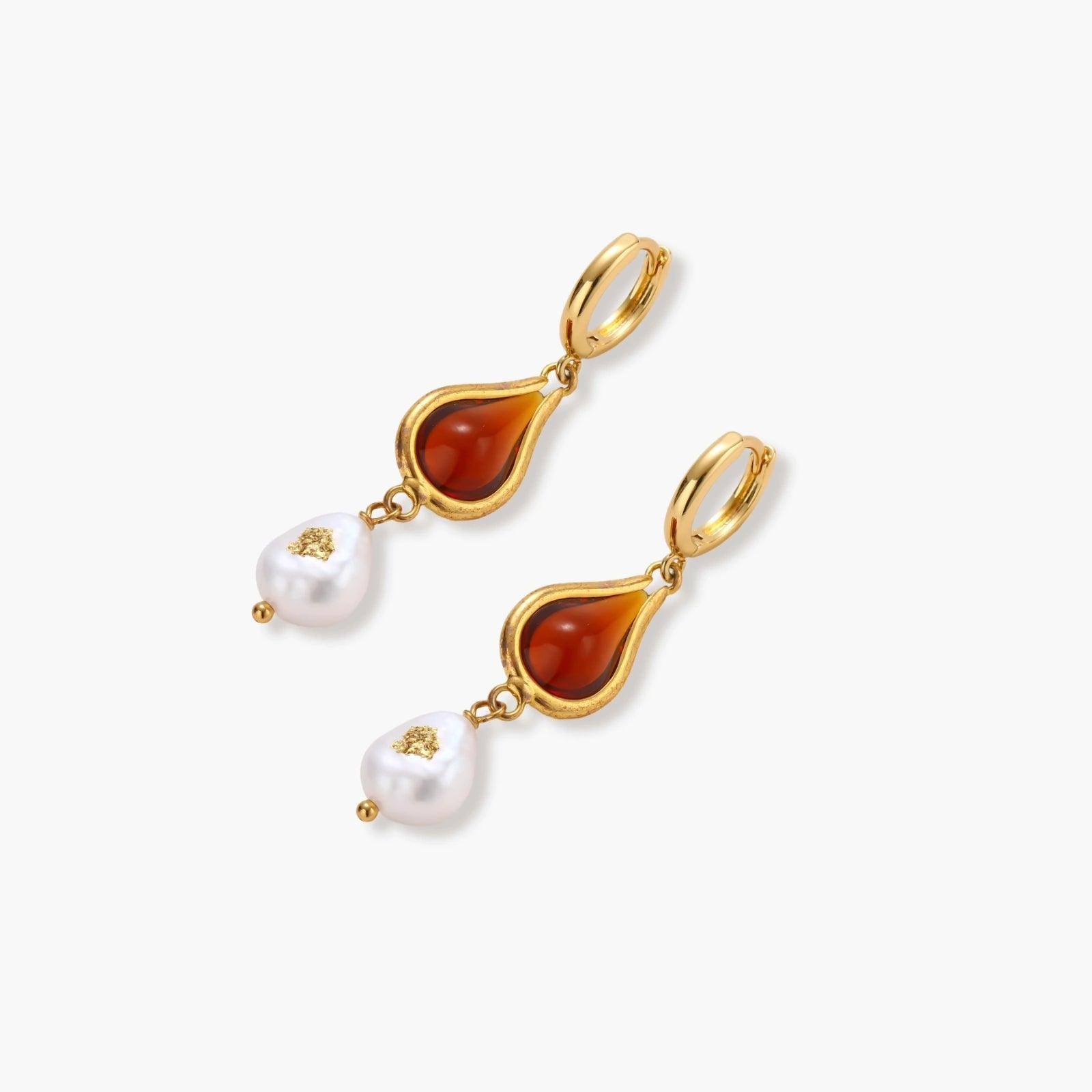 Gold-plated drop earrings featuring amber teardrops and white baroque pearls on light background.