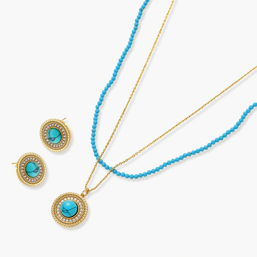 Gold-plated turquoise jewelry set with circular medallion pendant, beaded necklace, and matching stud earrings on white background