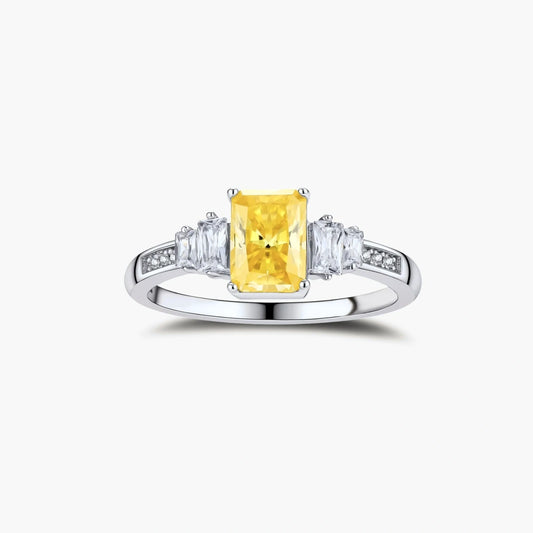 Sterling silver ring with emerald-cut yellow moissanite center stone and clear baguette side stones in elegant setting