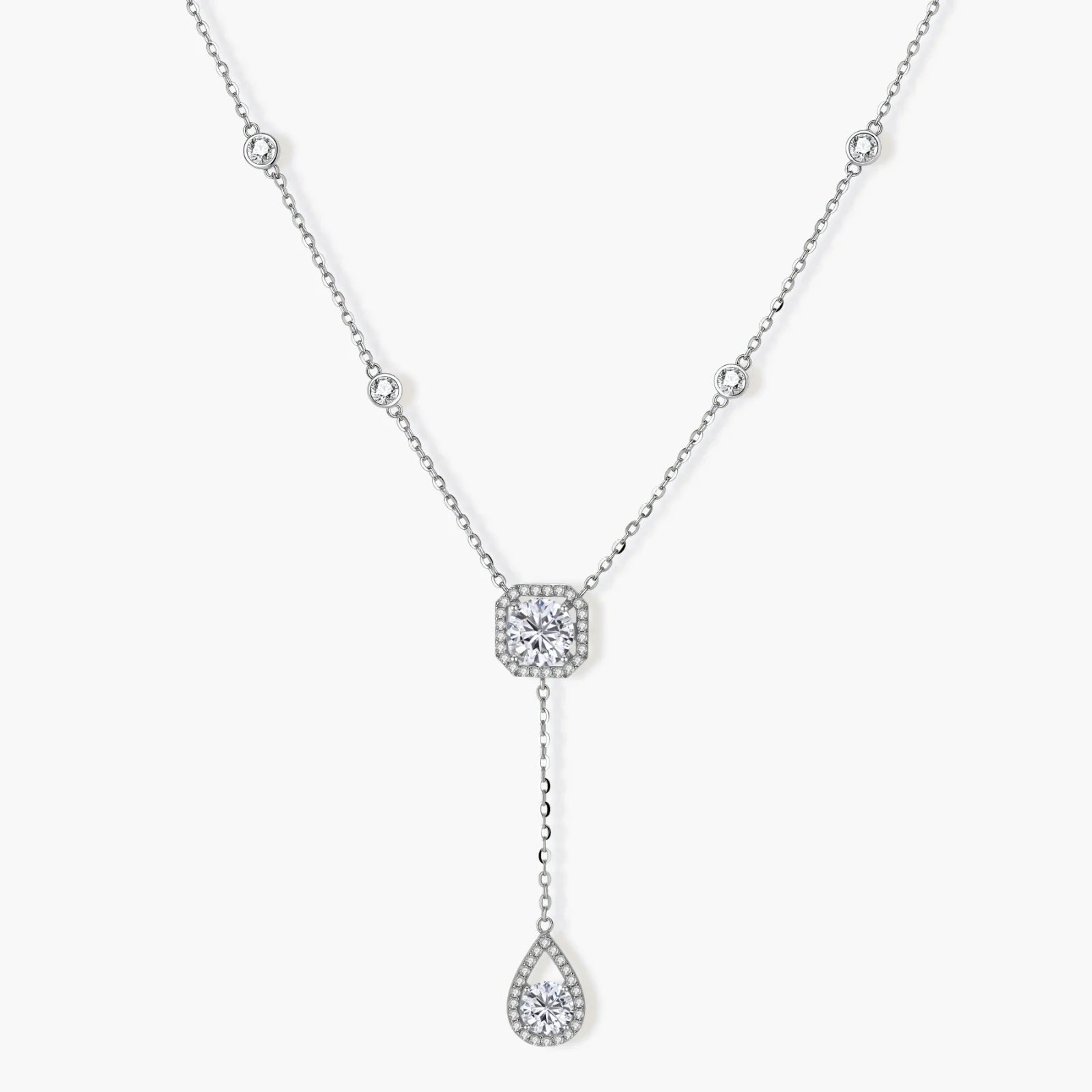 Sterling silver necklace with cushion-cut moissanite in halo setting and teardrop pendant, displayed on cream background.