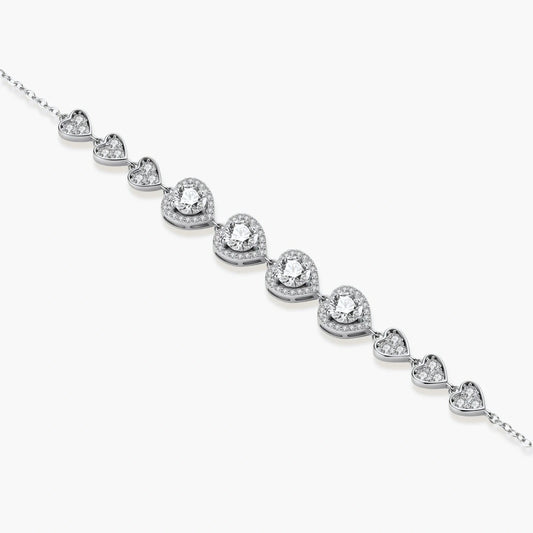 Sterling silver bracelet with graduated heart-shaped links and sparkling moissanite stones in VVS1 clarity on white background.