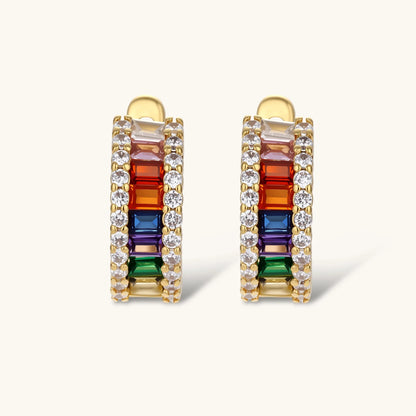 Gold-plated jewelry set featuring rainbow baguette-cut cubic zirconia stones in geometric design on cream background