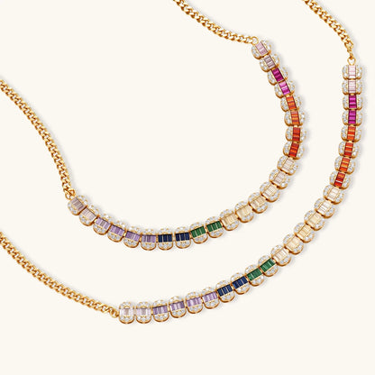 Gold-plated jewelry set featuring rainbow baguette-cut cubic zirconia stones in geometric design on cream background