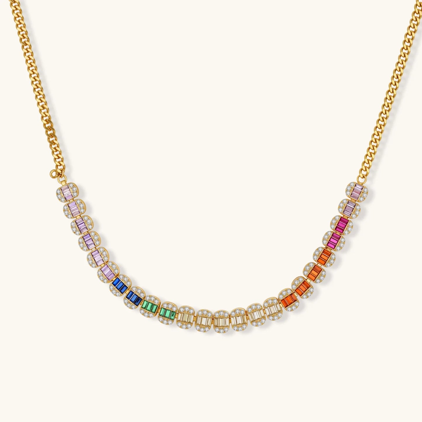 Gold-plated jewelry set featuring rainbow baguette-cut cubic zirconia stones in geometric design on cream background