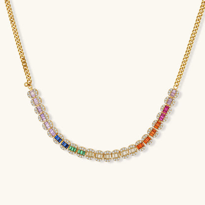 Gold-plated jewelry set featuring rainbow baguette-cut cubic zirconia stones in geometric design on cream background