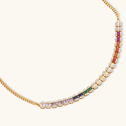 Gold-plated jewelry set featuring rainbow baguette-cut cubic zirconia stones in geometric design on cream background