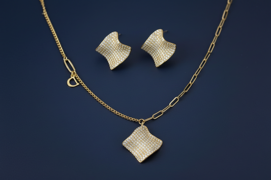 Gold-plated wavy jewelry set with crystal detailing featuring necklace with dual chains and matching textured earrings