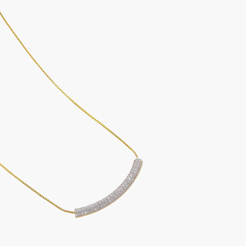 Gold-plated curved necklace, hoop earrings, and adjustable ring with pavé cubic zirconia stones on cream background.