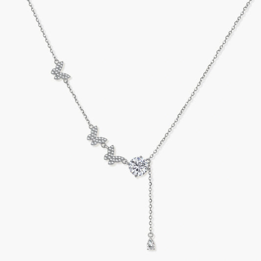 Sterling silver lariat necklace featuring three delicate butterfly charms and a brilliant round moissanite drop.