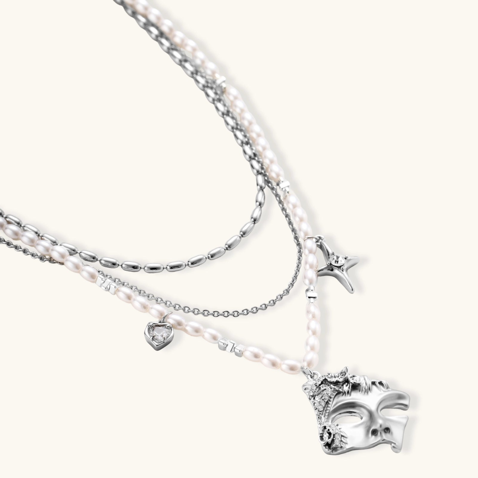 Multi-strand layered necklace set with silver chains, white pearls, star charm, heart pendant, and ornate decorative piece