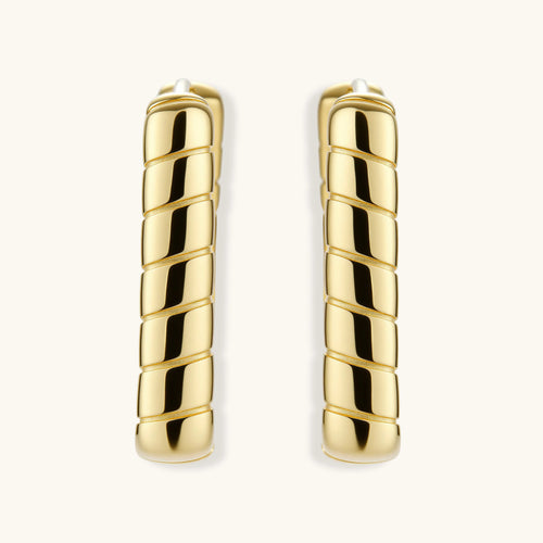 Chunky segmented gold-plated huggie hoop earrings with bamboo-inspired geometric design on white background.