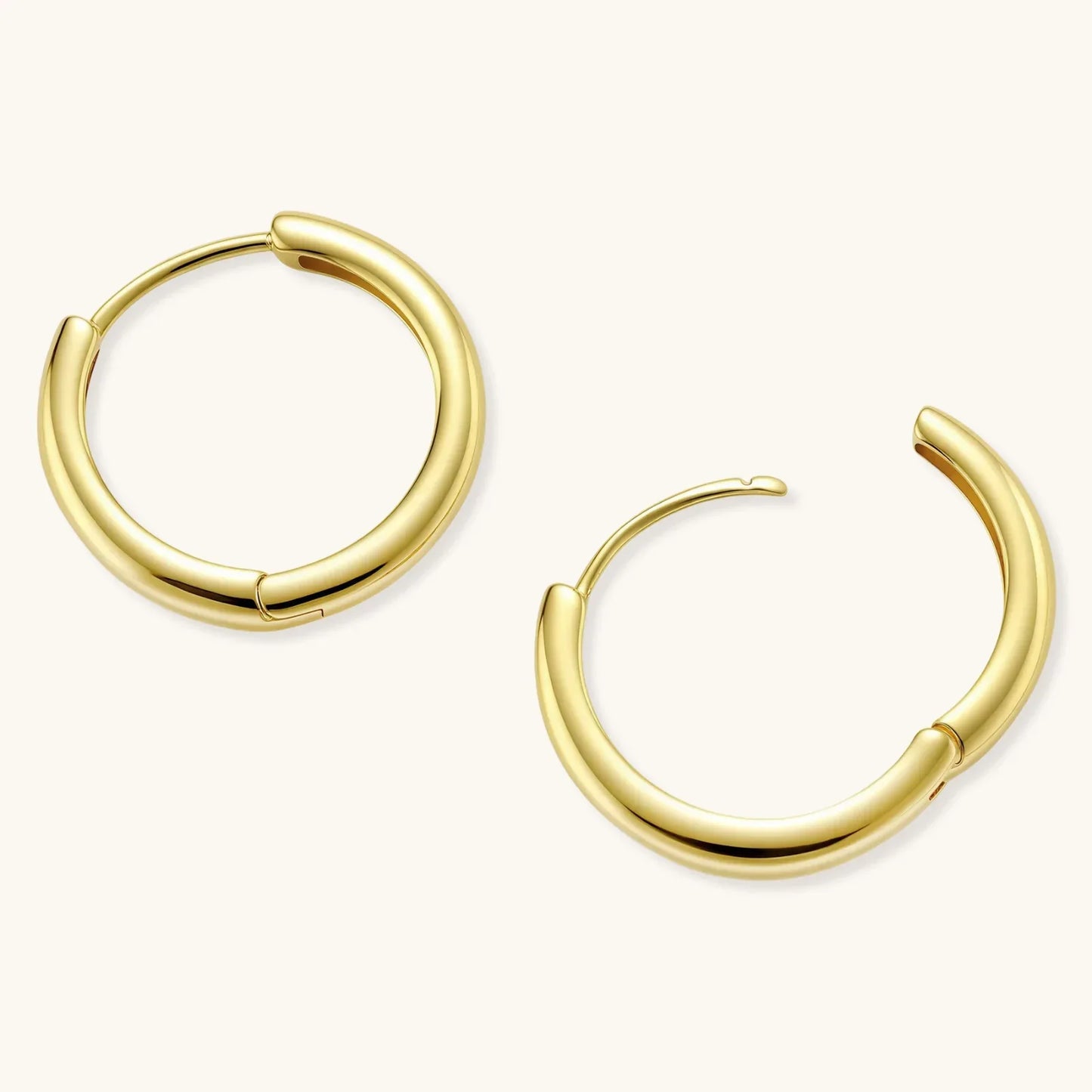 Polished gold-plated sterling silver hoop earrings with hinged closure mechanism on white background.