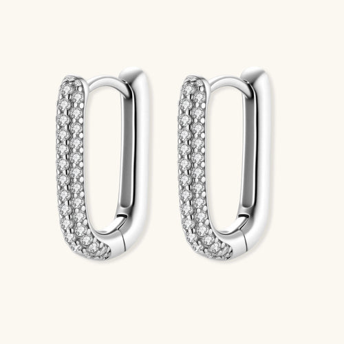 Close-up of small sterling silver huggie hoops completely covered in sparkling clear crystals with hinged closure