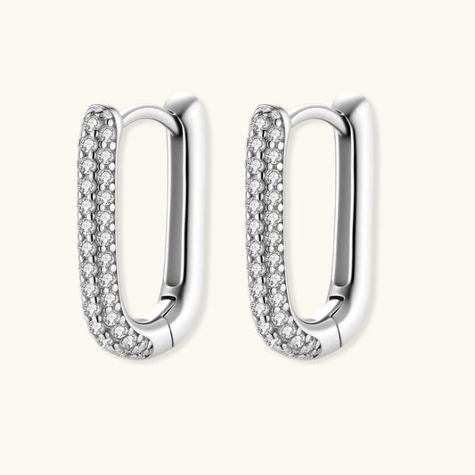 Close-up of small sterling silver huggie hoops completely covered in sparkling clear crystals with hinged closure