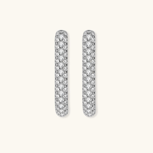 Close-up of small sterling silver huggie hoops completely covered in sparkling clear crystals with hinged closure