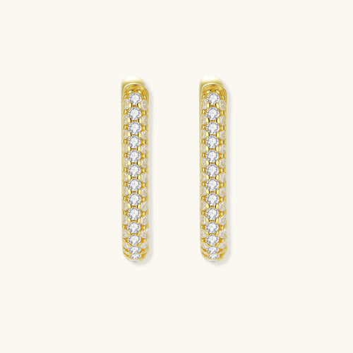 Close-up of small sterling silver huggie hoops completely covered in sparkling clear crystals with hinged closure