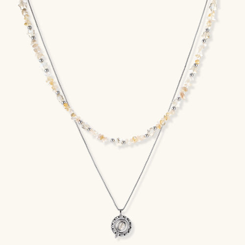 Two-layer necklace featuring raw citrine-toned chips, silver beads, and a circular openwork pendant with zirconia.