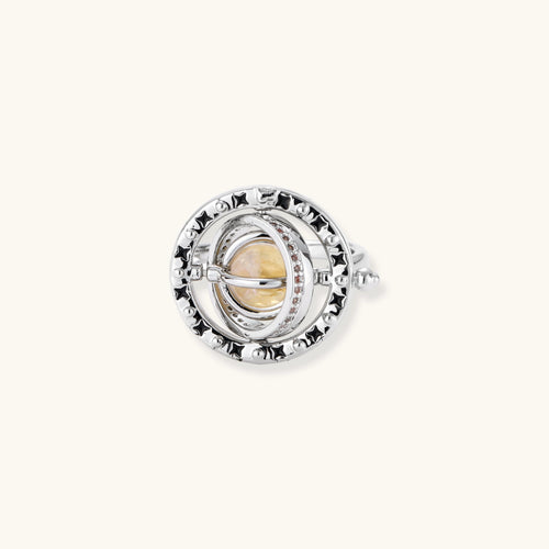 Adjustable brass ring with rotating zirconia center, surrounded by black enamel celestial stars and moon details
