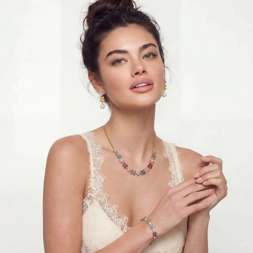 Model showcasing the vibrant Garden Bloom Jewelry Set, featuring a floral necklace, bracelet, and pearl-adorned earrings.