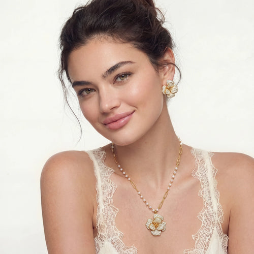 Model showcasing the elegant Blooming Sapphire Set with a floral pendant necklace and matching flower-shaped earrings.