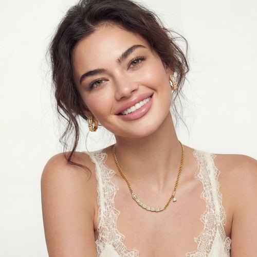 Model showcasing a curb-chain necklace with sparkling stones and coiled snake huggies, exuding elegance and sophistication.