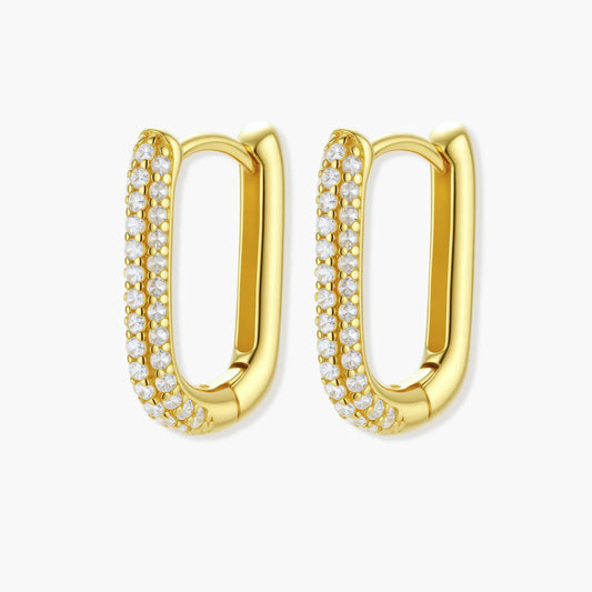 Elongated rectangular huggie earrings in warm gold tone, adorned with shimmering pavé stones and a hinged click closure.