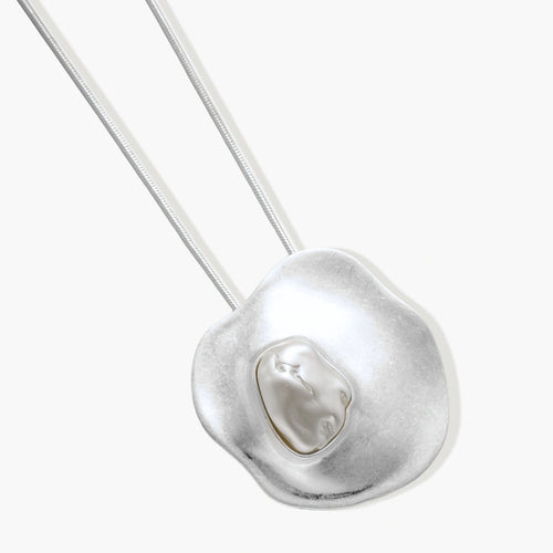 Organic curved earrings and necklace featuring baroque pearls in eco-zinc alloy settings on neutral background