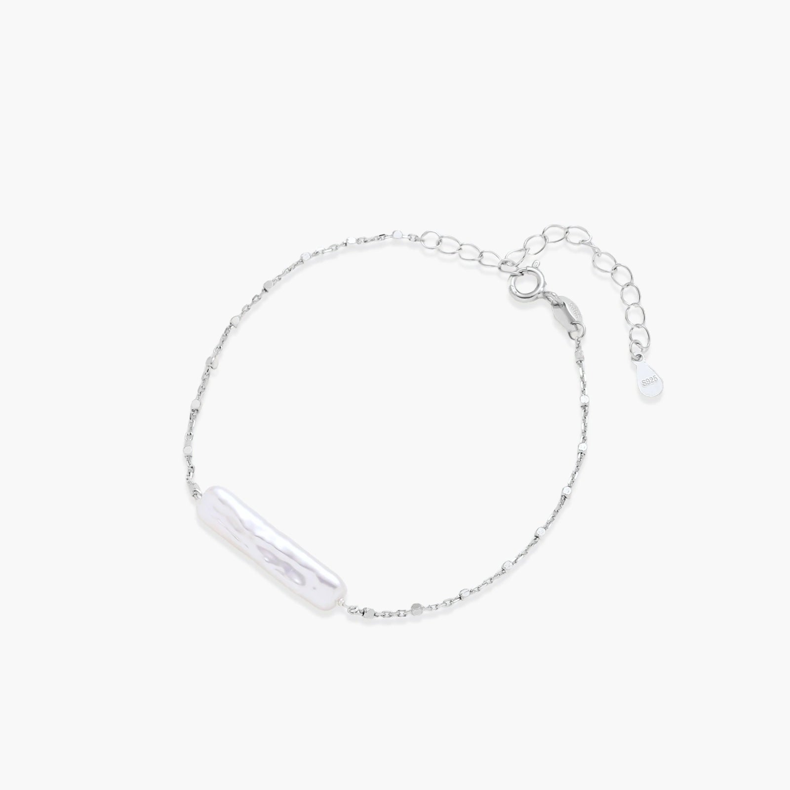 Minimalist bracelet featuring a long, rippled baroque pearl on a delicate chain with an adjustable extender.