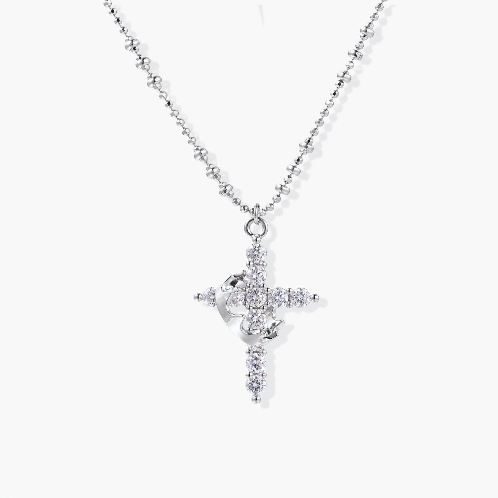 Delicate white gold-plated cross pendant adorned with sparkling zirconia stones on a faceted bead chain.