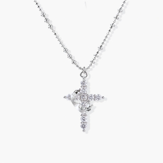 Delicate white gold-plated cross pendant adorned with sparkling zirconia stones on a faceted bead chain.