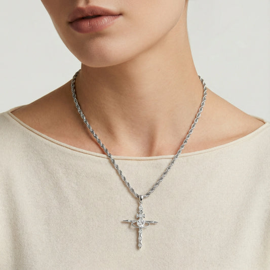 Silver-toned cross pendant elegantly suspended on a twisted rope chain, showcasing timeless sophistication.