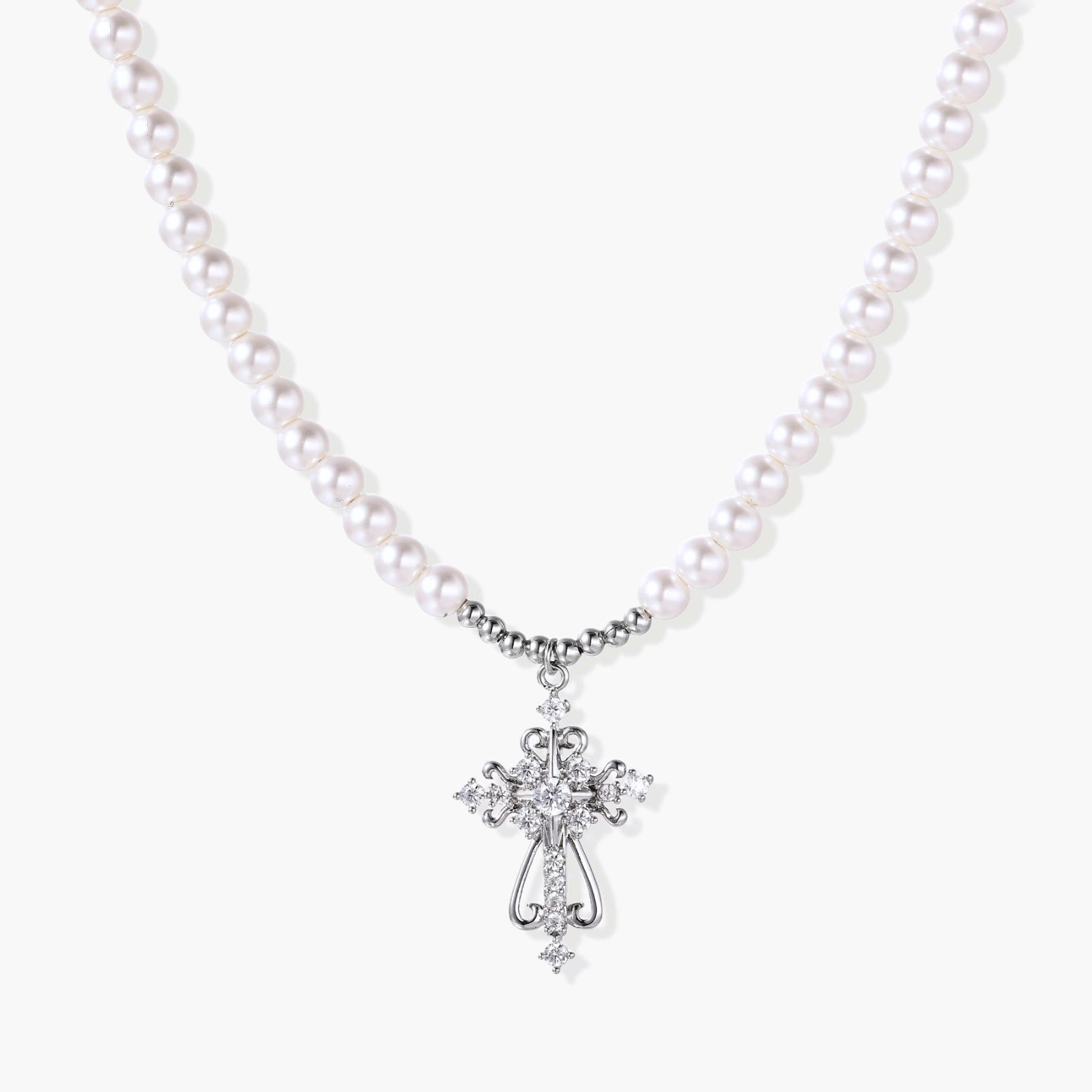 Elegant white pearl necklace featuring a scrolled silver cross pendant adorned with sparkling zirconia stones.