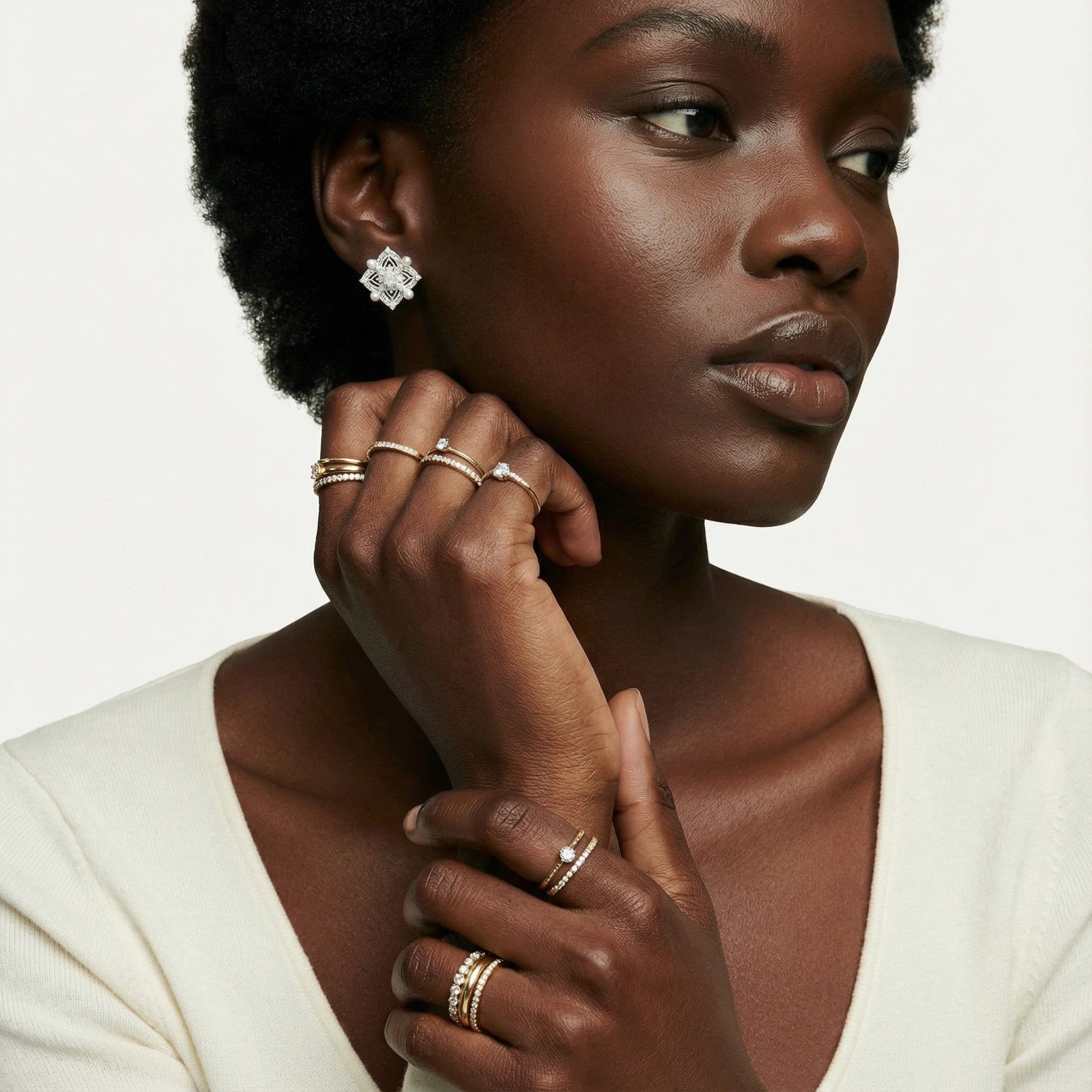 Model showcasing elegant sterling silver quatrefoil earrings adorned with freshwater pearls, styled with minimal accessories.