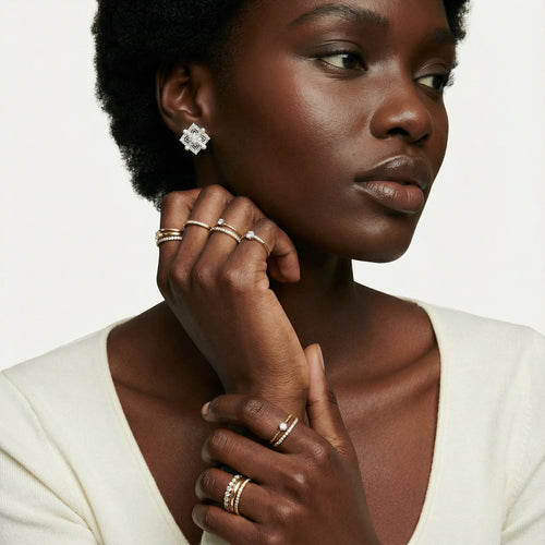 Model showcasing elegant sterling silver quatrefoil earrings adorned with freshwater pearls, styled with minimal accessories.