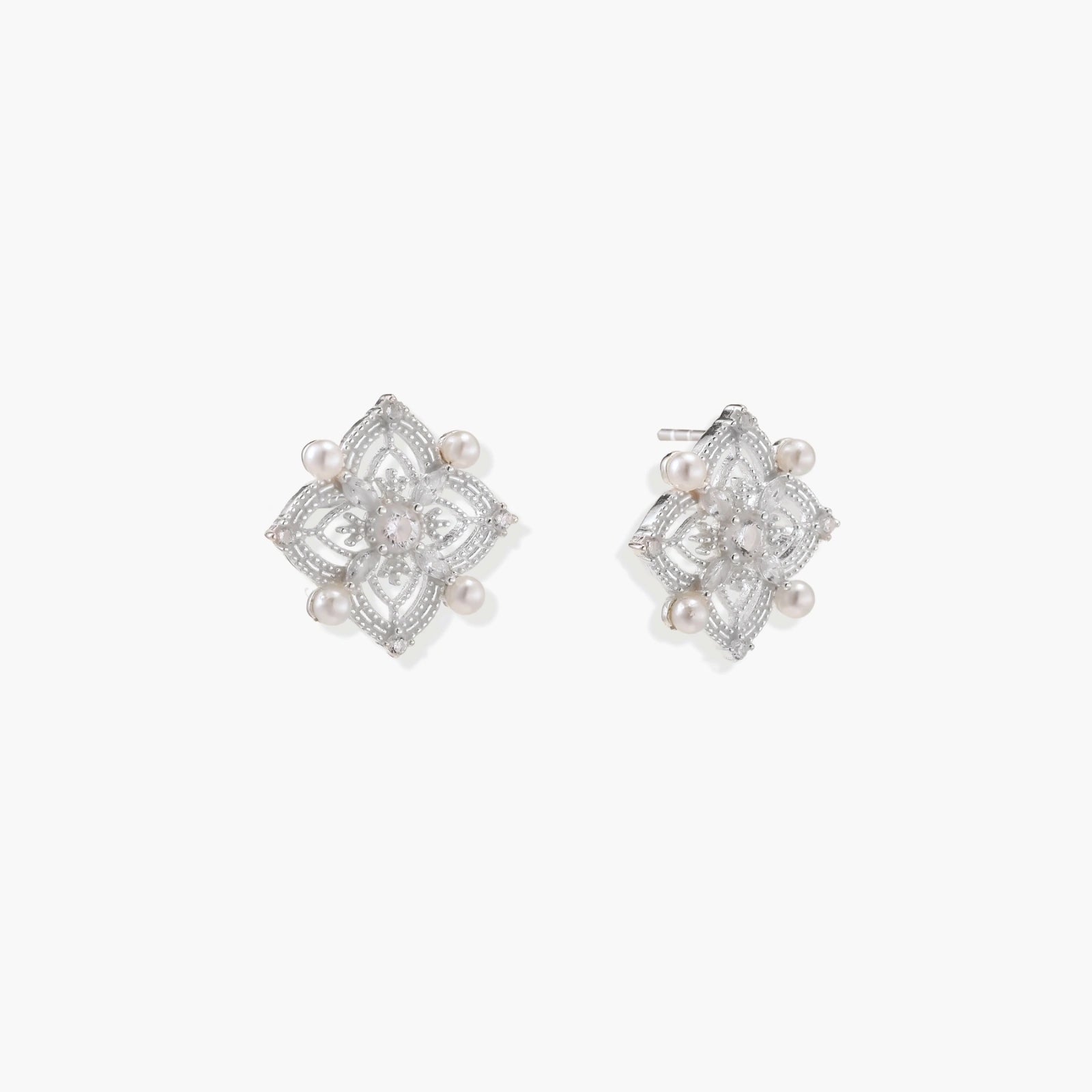 Delicate sterling silver quatrefoil stud earrings featuring four elegant freshwater pearls, exuding timeless sophistication.
