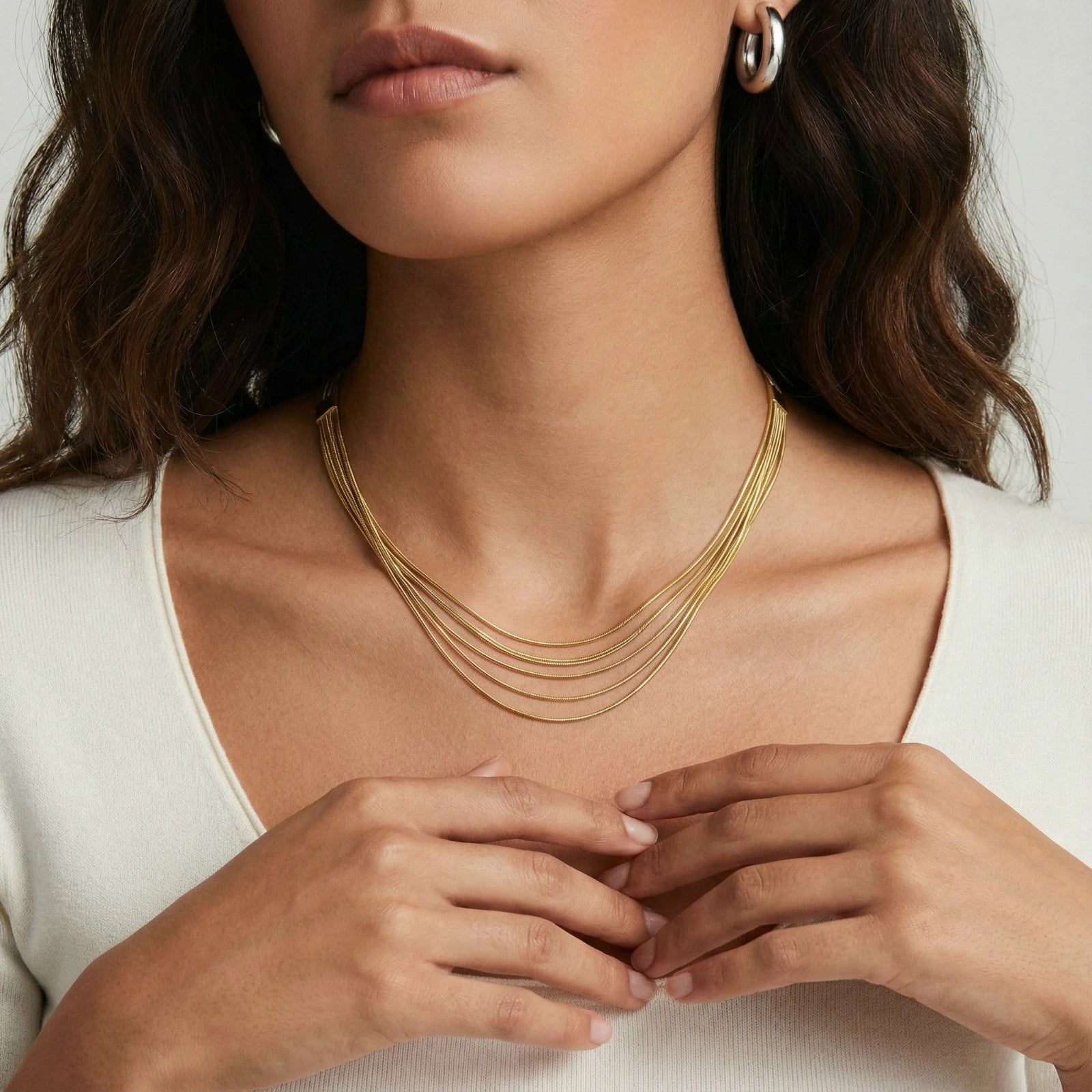 Seven elegant gold-plated snake chains layered gracefully around the neck, showcasing refined sophistication.