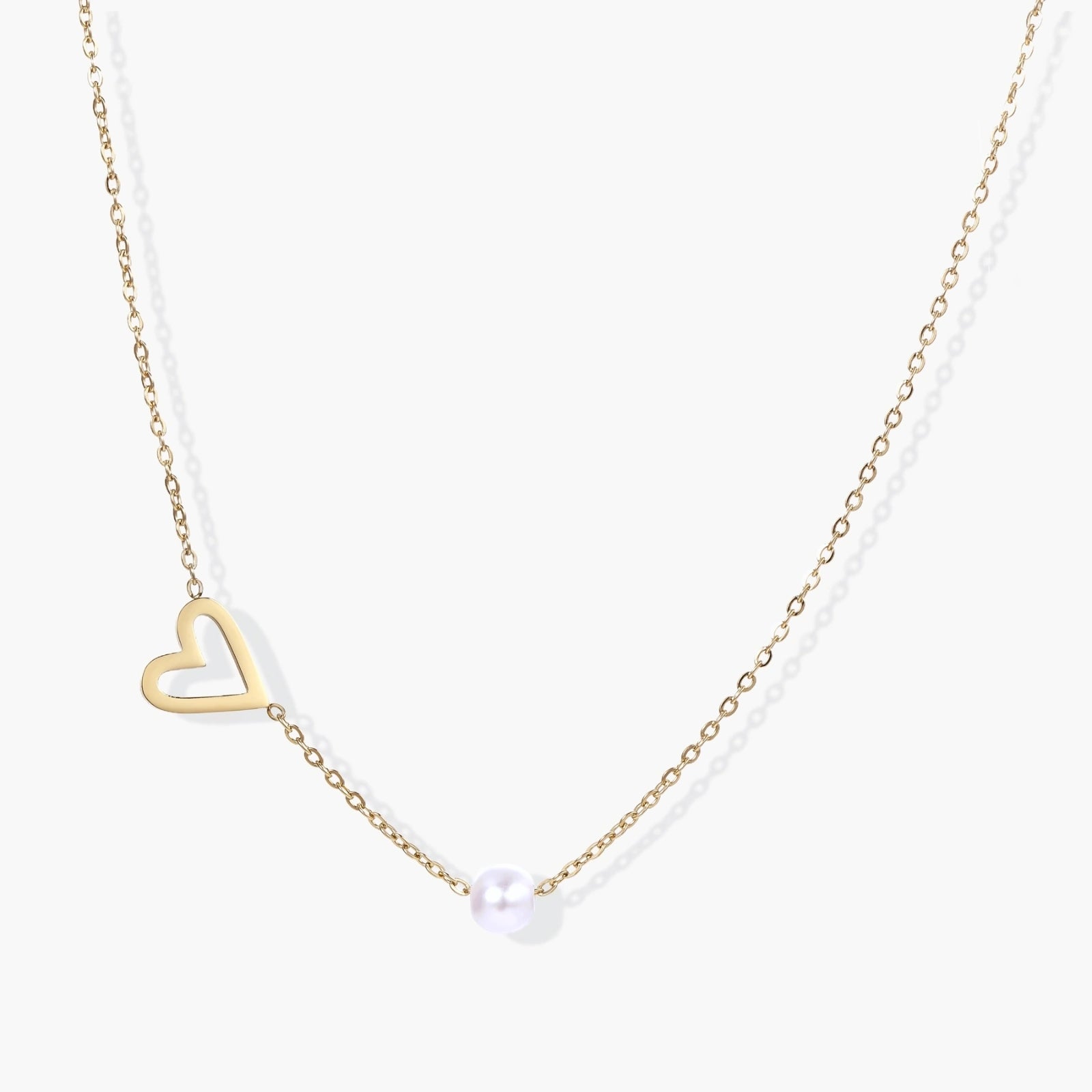 Delicate gold necklace featuring a tilted open heart design with a lustrous white pearl on a fine chain.
