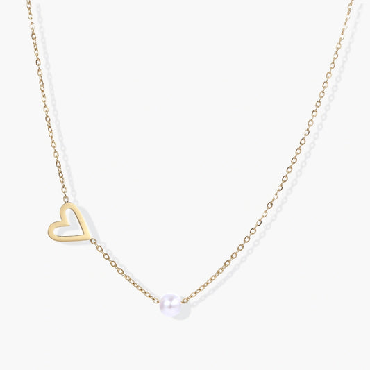 Delicate gold necklace featuring a tilted open heart design with a lustrous white pearl on a fine chain.