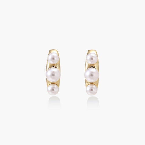 14K gold-plated curved stud earrings with three white freshwater pearls aligned vertically on cream background