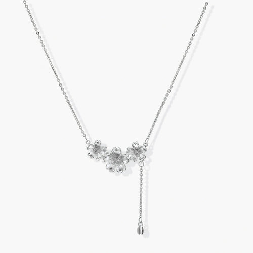 Delicate silver-toned lariat necklace featuring three flower charms and a charming bud pendant for versatile elegance.