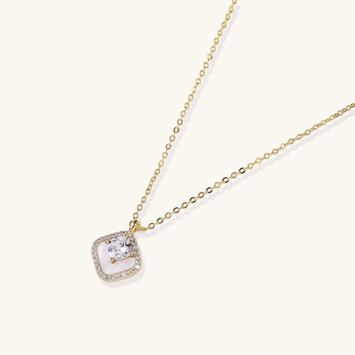 Cushion-shaped pendant featuring a clear faceted stone above a cream inlay, elegantly framed by a pavé halo.